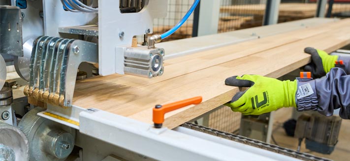 technician feeding staves into edge gluing machine